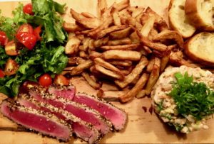 Tataki de thon frites salade avec tomates, tartare de saumon et croûtons de pain